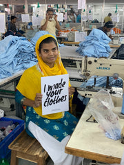Garment worker holding "I made your clothes" sign