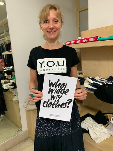 Sarah at our factory in India holding a Who Made My Clothes sign