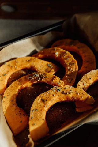 Seasoned pumpkin slices in a pan