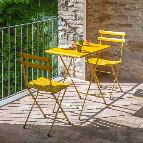 Photo of two Arc en Ciel chairs with 334 folding table in Antique Curry Yellow finish