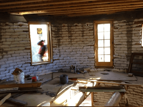 Interior of 1000 square foot unfinished circular earthbag structure - made of thousands of white polypropylene sandbags