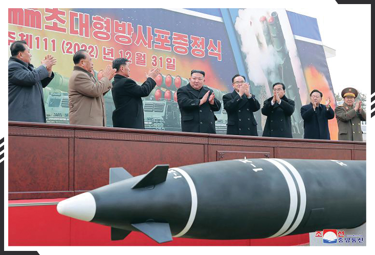 Kim Jong-un clapping with officers in front of missile