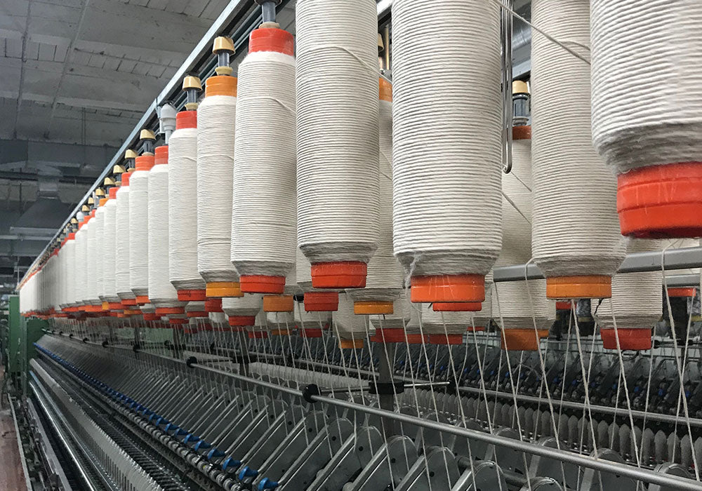 Hemp fiber being spun into natural fiber yarn with organic cotton
