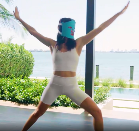 Woman exercising while wearing a  HigherDOSE Red Light Face Mask