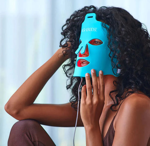 Woman using a HigherDOSE Red Light Face Mask Skin