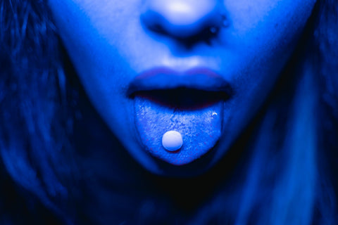 Woman with a drug tablet on her tongue