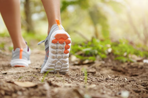 A person walking outdoors in gray rubber shoes