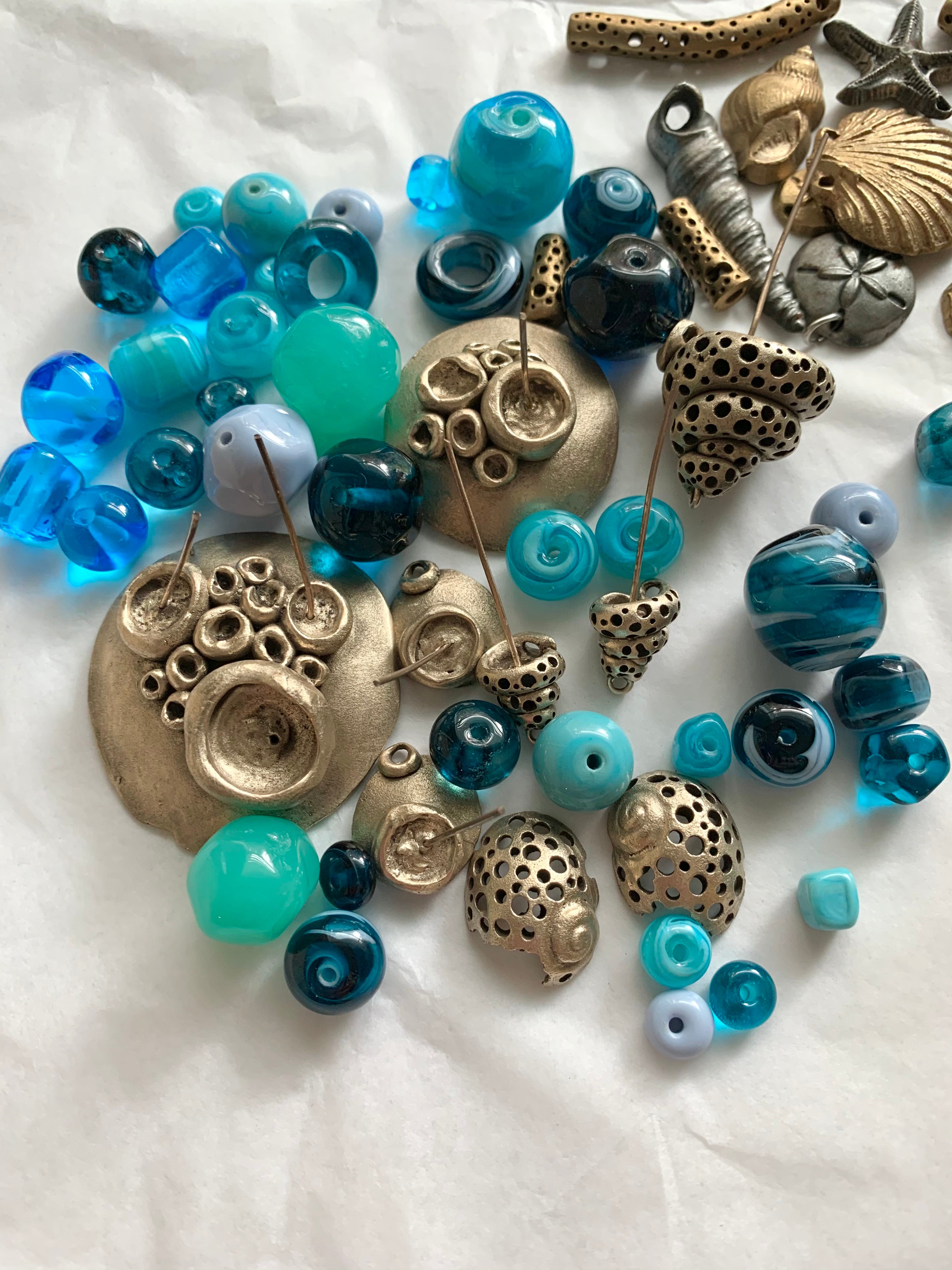 Blue artisan glass beads mingle with bronze handmade jewelry pieces