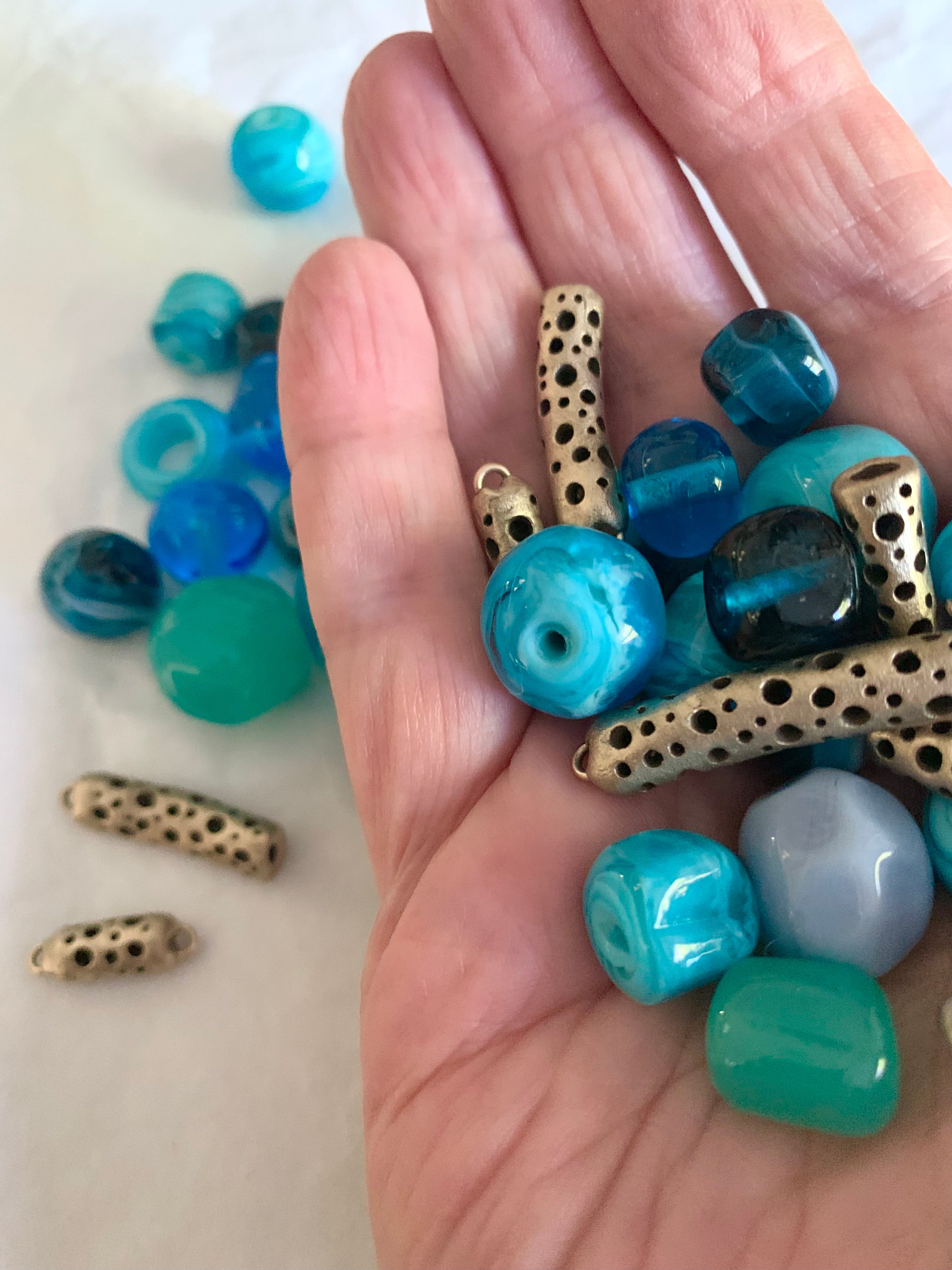 Blue glass and bronze beads in hand
