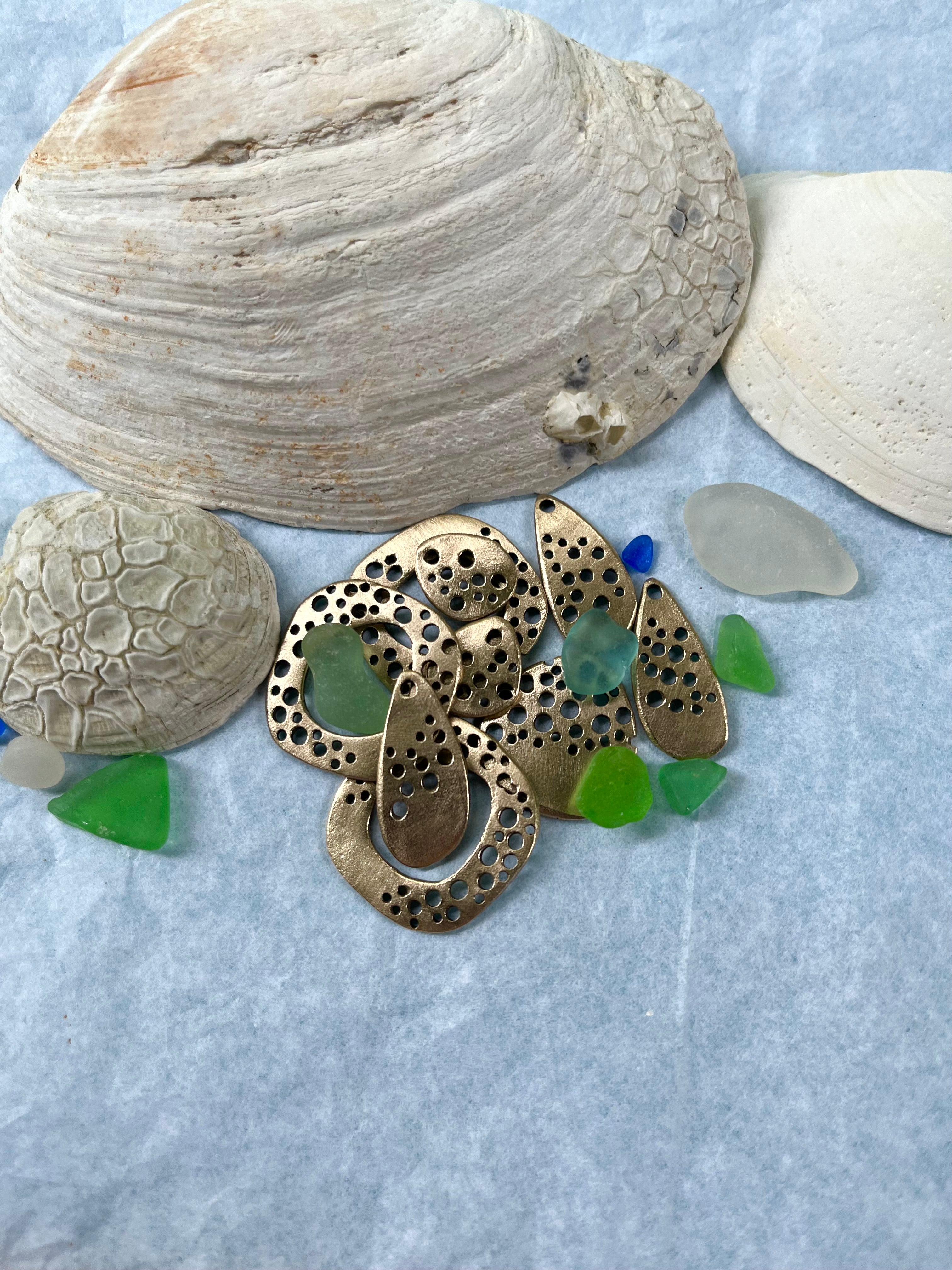 Shells with handmade bronze jewelry pieces and seaglass