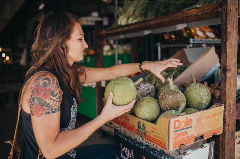 Sarah is picking breadfruit at a farmer's market in Hawai'i.