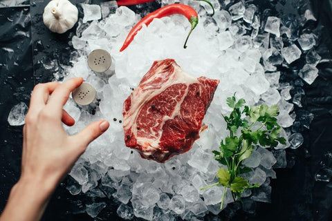 A piece of raw meat sits on top of a bed of ice