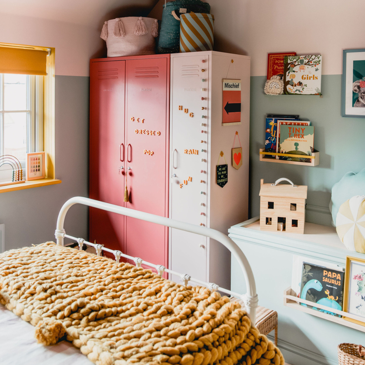 A Berry Twinny and a Blush Skinny sit side-by-side at the foot of a bed. Wordbits magnets spell out 'get dressed' on the front and colorful baskets sit on top.