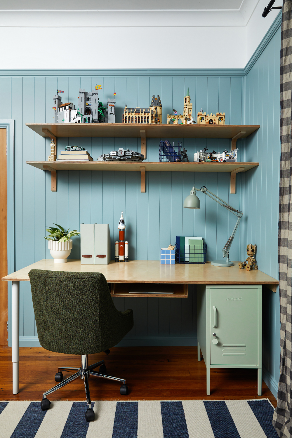 Dylan's desk is accessorised with an olive boucle chair and a Sage Shorty. On the shelves above the desk are an assortment of intricately assembled Lego projects.