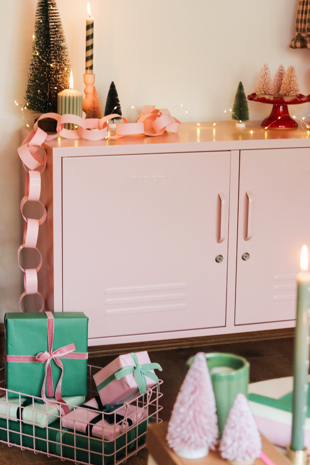 A Blush Lowdown is strewn with fairy lights, streamers and decorations. On the floor are a stack of gift-wrapped presents in Mustard Made baskets.