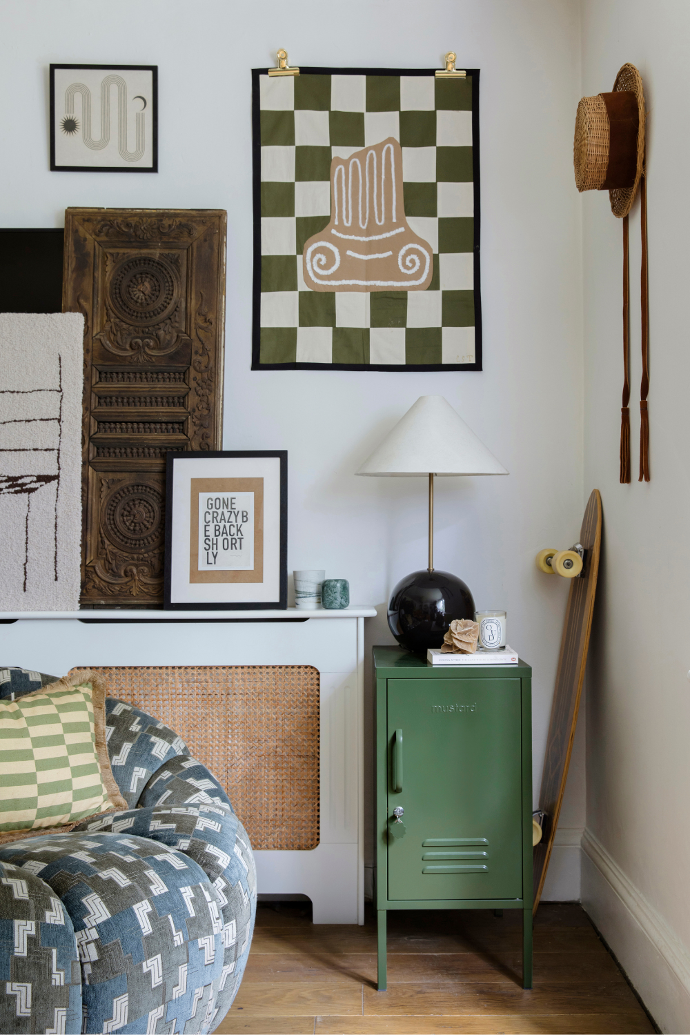 An Olive Shorty is arranged in a room styled in green and earth tones. An art print reads 'gone crazy be back shortly.'