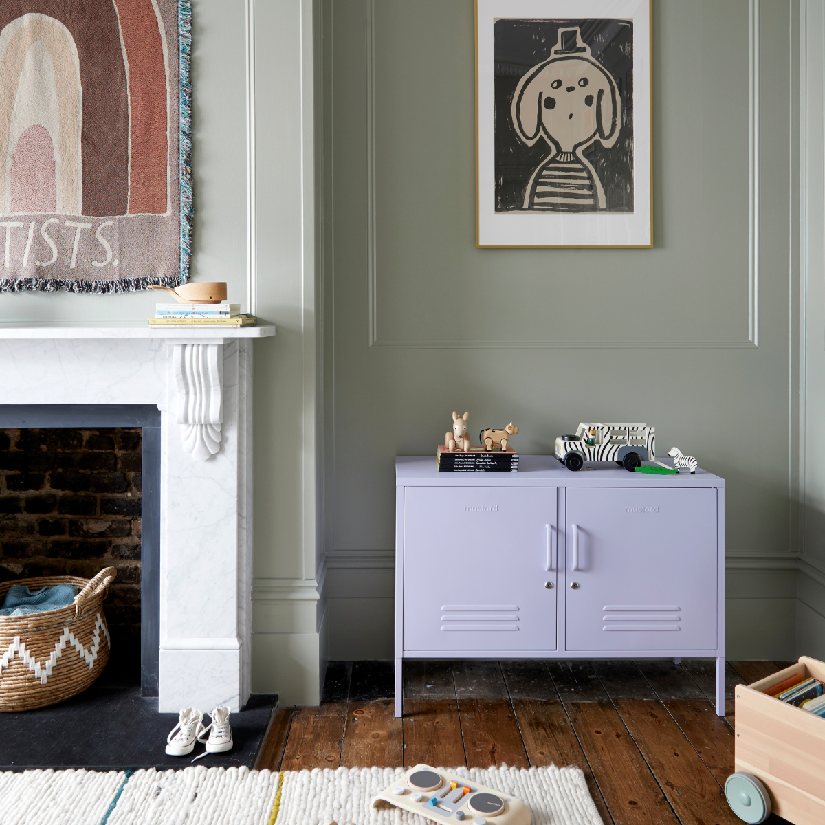 The Lowdown in Lilac sits next to a white marble fireplace.