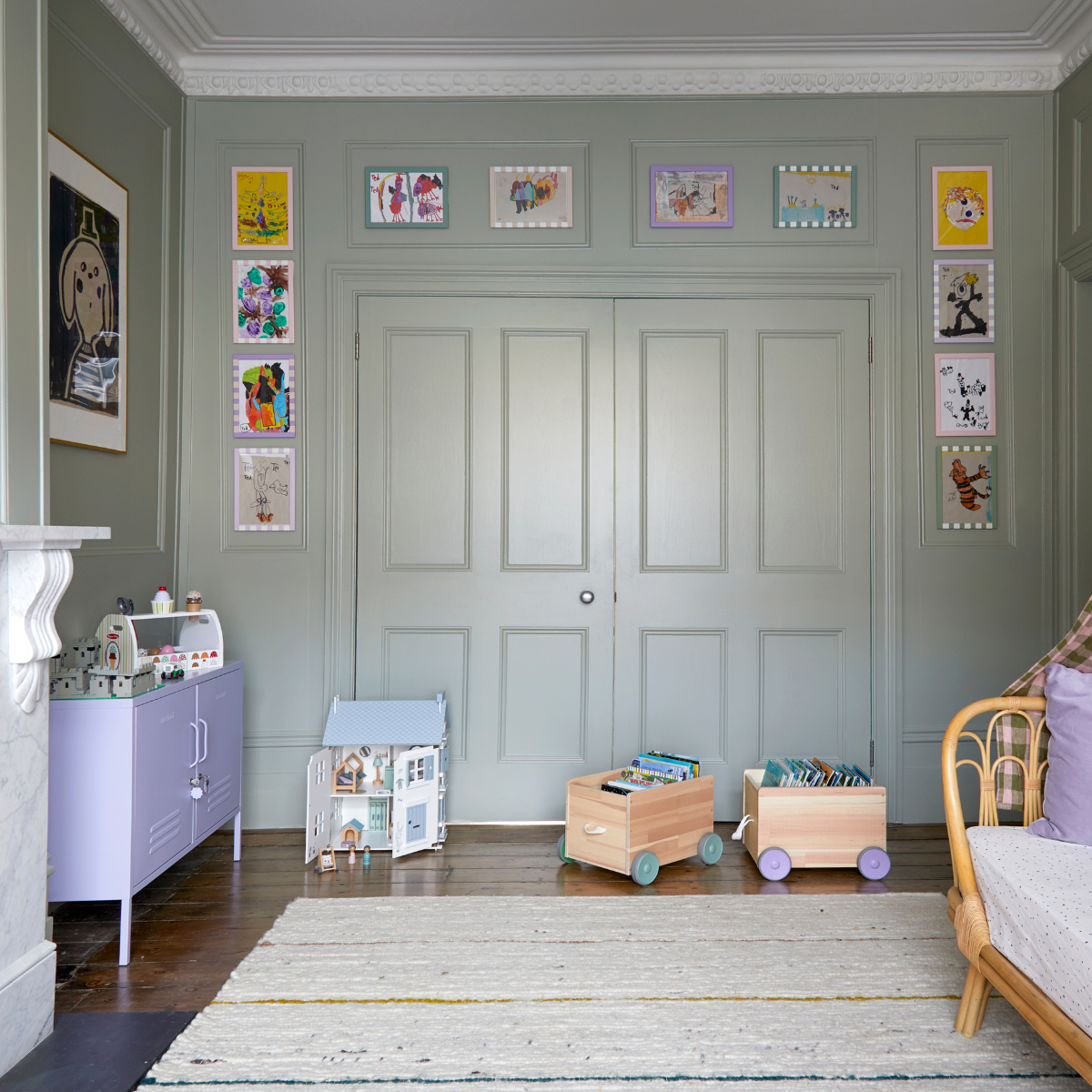 A playroom with painted green walls, a Mustard Made Lilac Lowdown locker and toys.