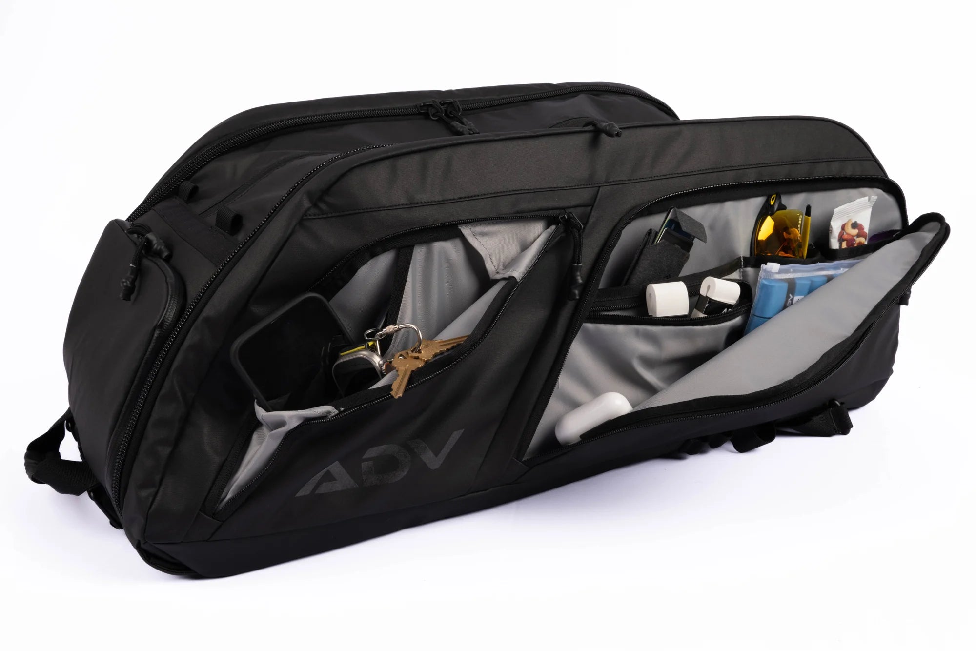 Black travel bag with multiple compartments, holding keys, sunglasses, and small accessories.