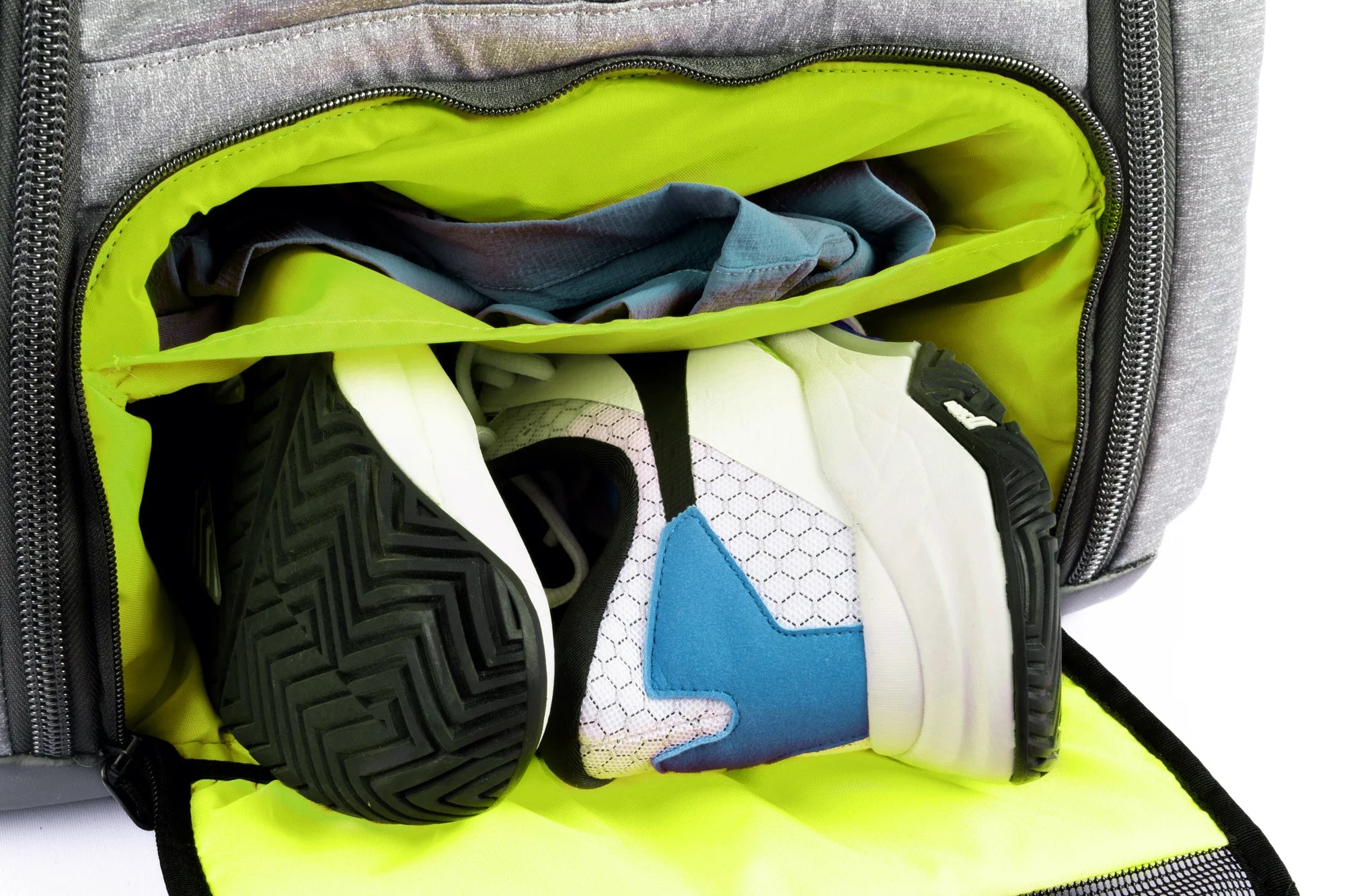 Open backpack pocket with sneakers and clothing inside.