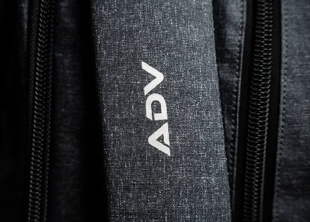 Close-up of fabric with zippers and 'ADV' text.
