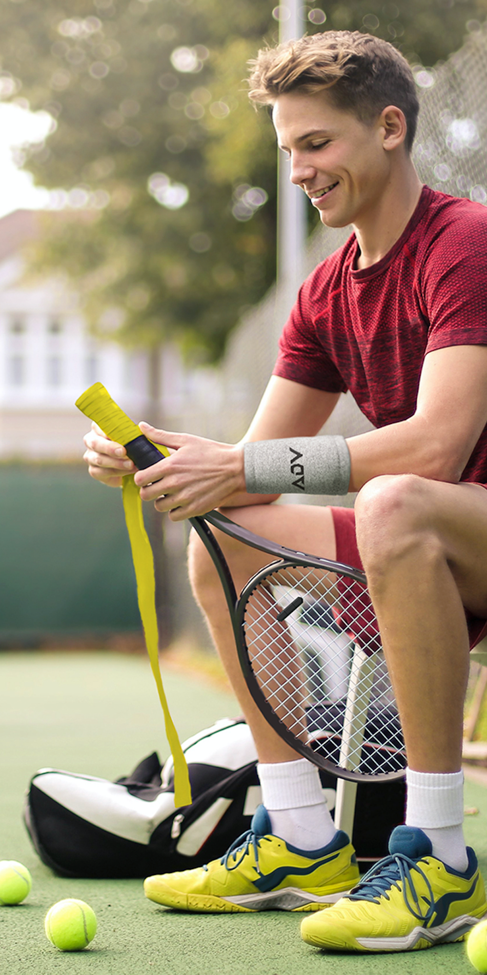 A young athlete sitting on a bench and wrapping a grip tape on a tennis racket
