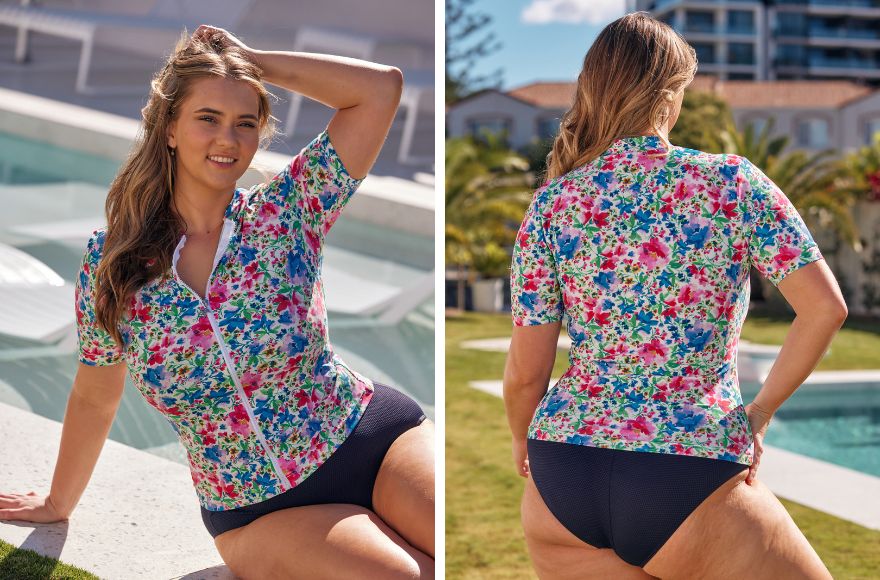 Woman with long bronde hair wears brightly coloured floral short sleeve rashie with plain navy pants