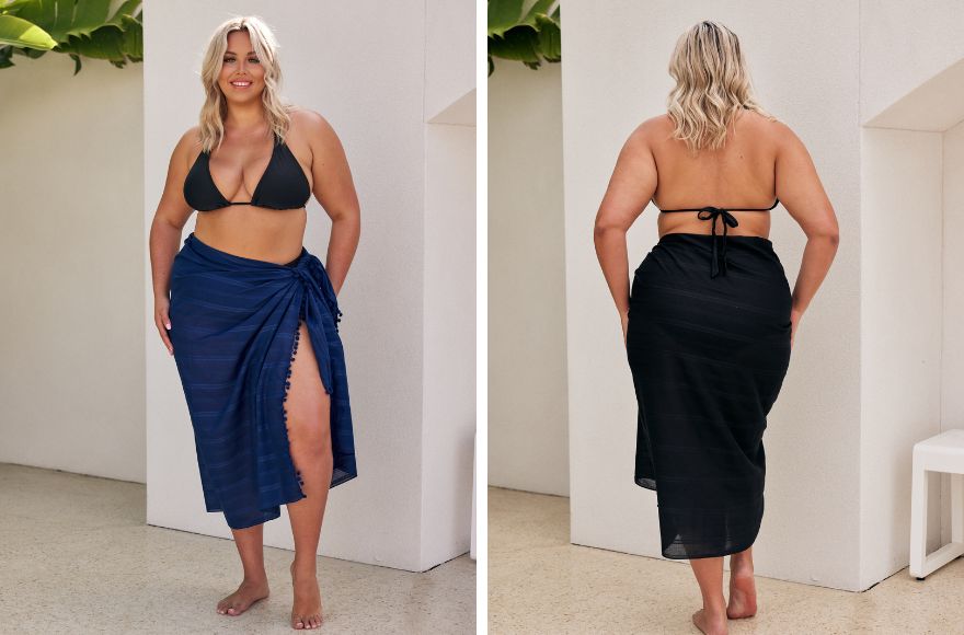Woman with blonde hair wears black triangle top with a navy sarong skirt