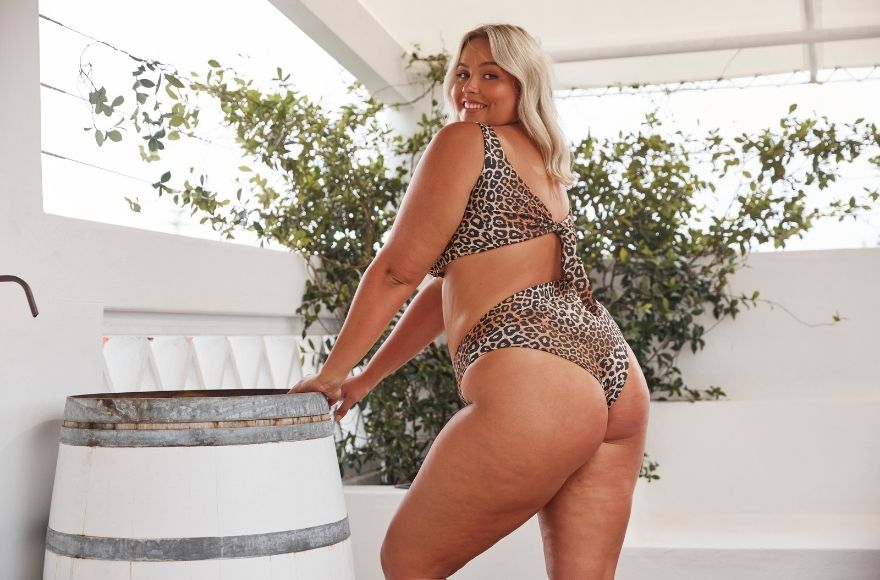 Woman with blonde hair wears leopard print high cut cheeky bikini bottoms with matching top