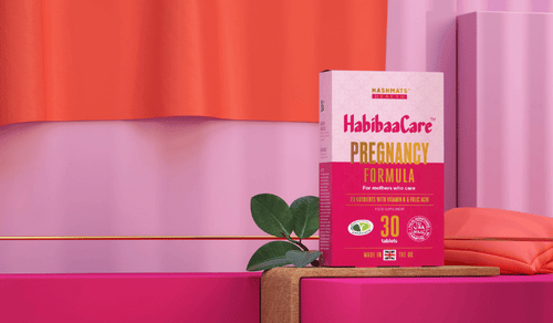 Hashmats Health Pregnancy Vitamins appear on a shelf with a pink and orange background.