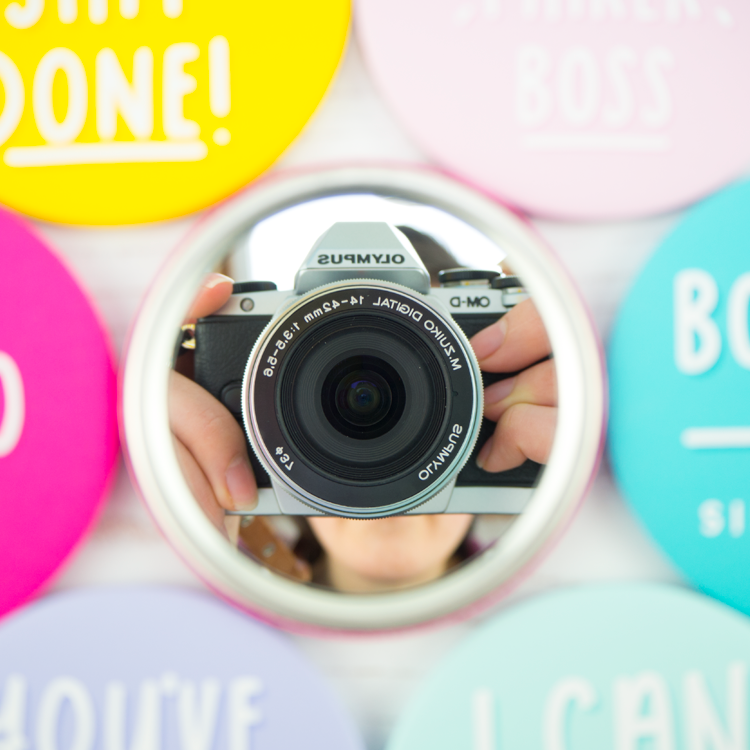 An image about getting featured on Joanne Hawkers Instagram account and on Hey There Maker. It features the reflection of her digital camera in the back of one of her brightly coloured motivational pocket mirrors