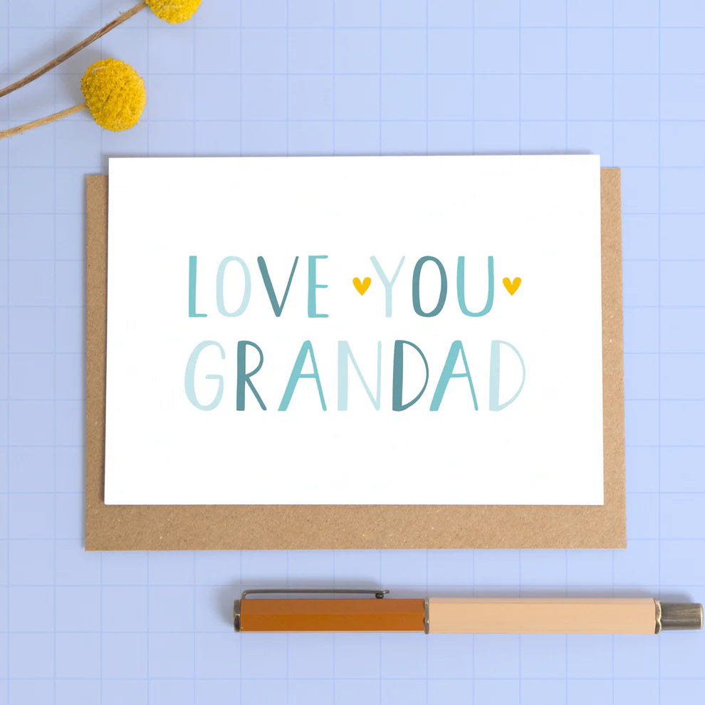 Love you Grandad greeting card on a blue background with a kraft envelope.