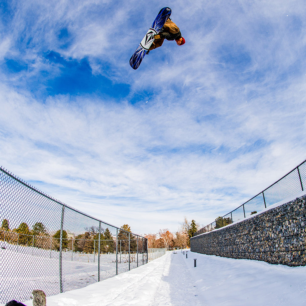 Pat Moore spinning a huge indi air over two fences on his snowboard.