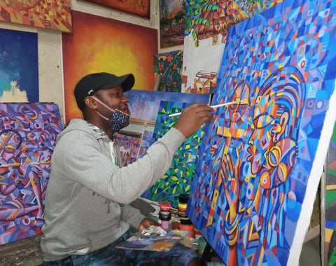 Afrikanischer Künstler malt eine Collage aus Farben. Angu Walters aus Kamerun. Wahre afrikanische Kunst.com