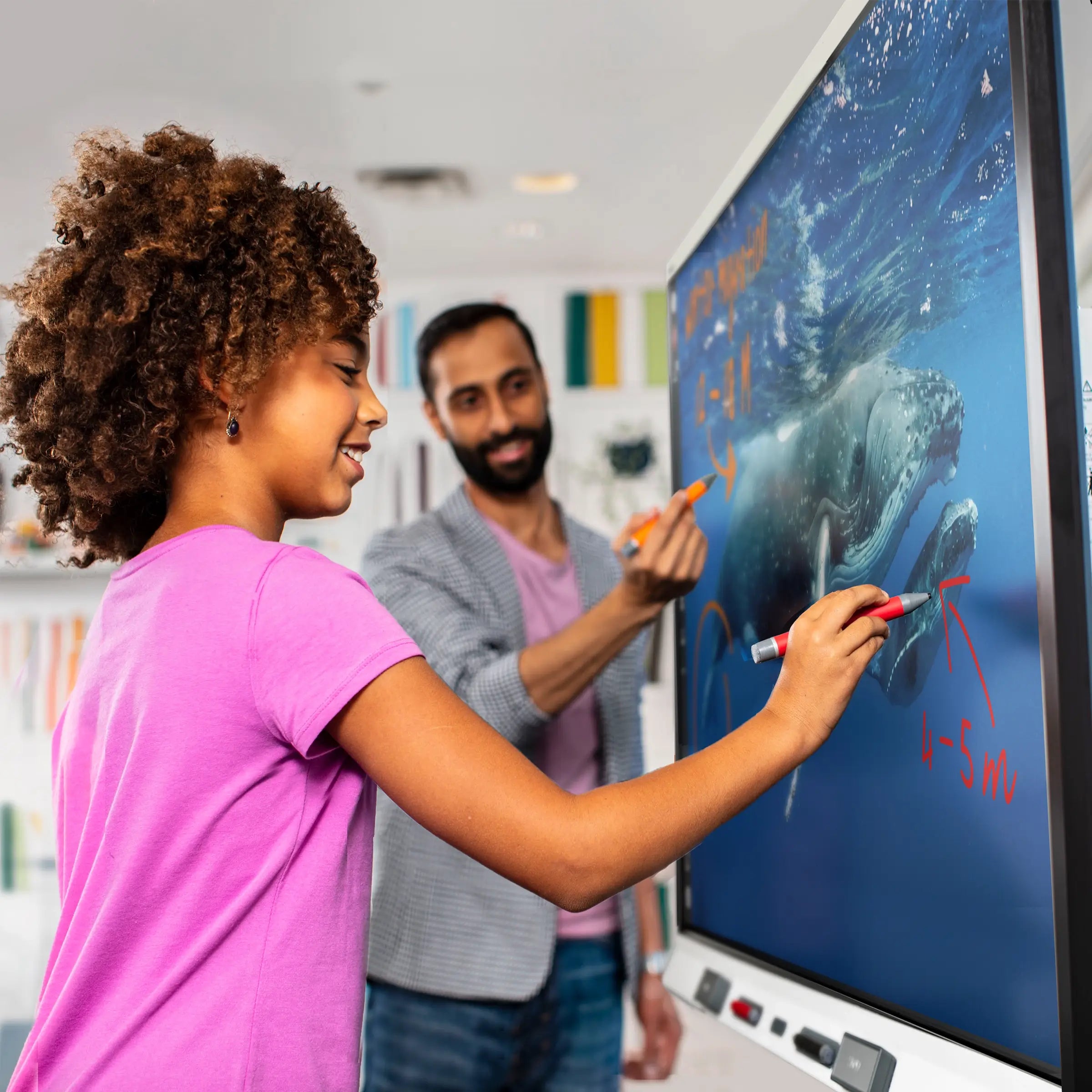 Image of a bunch of children in a music classroom, with one child writing on a SMART Board 