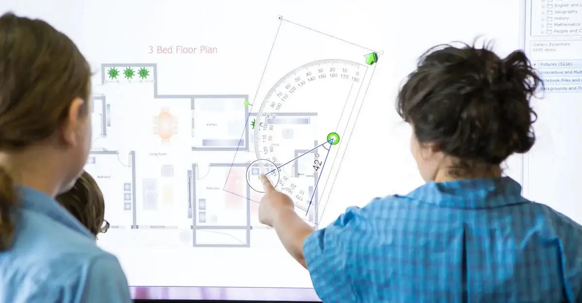 Image of a teacher helping a few students understand math problems using a SMART Board 