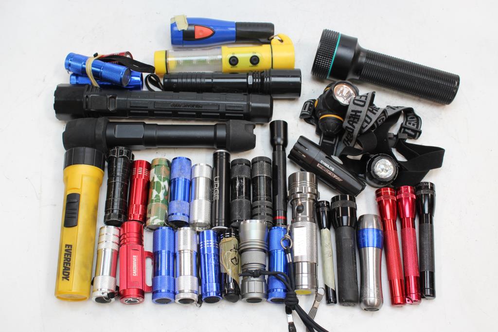 a random assortment of different flashlights all sitting side by side on a flat surface