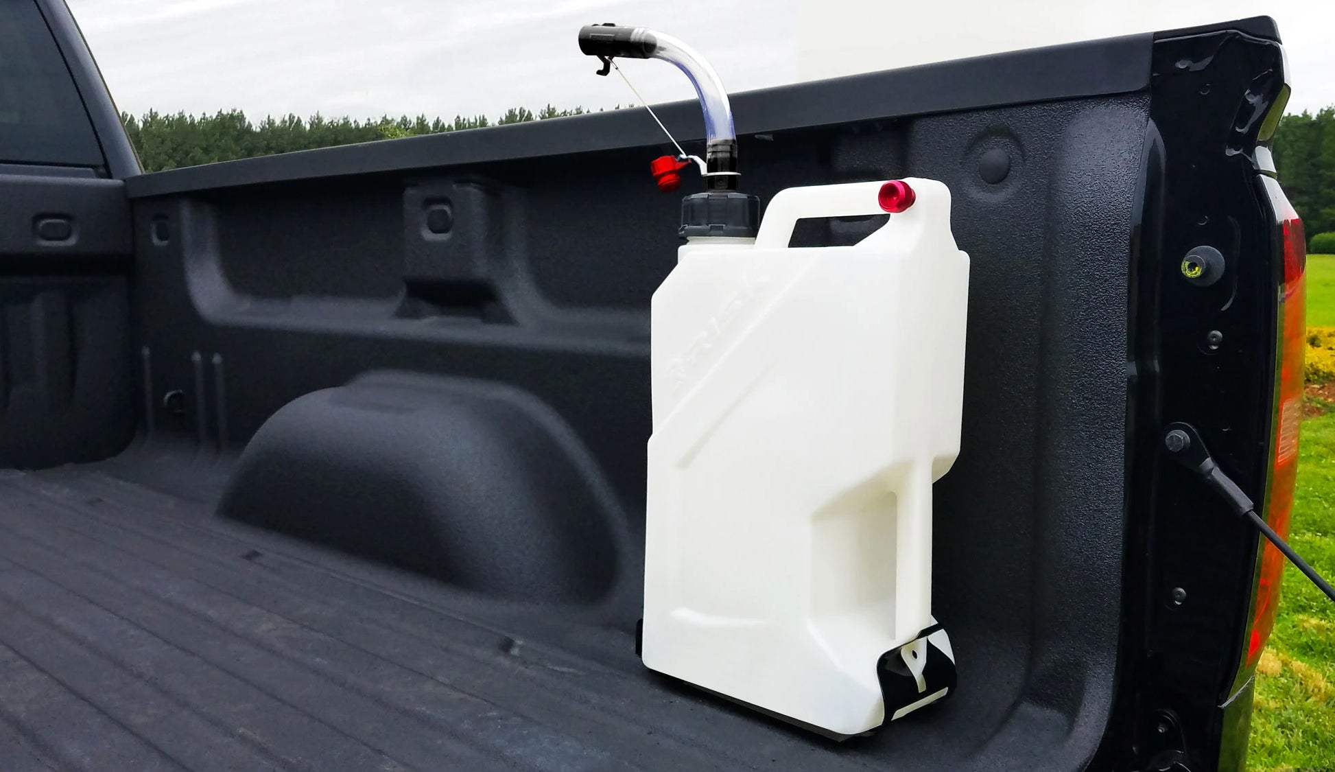 Lifestyle image of an EZ3 utility jug with clear hose bender mounted in the back of a truck with the EZ mount