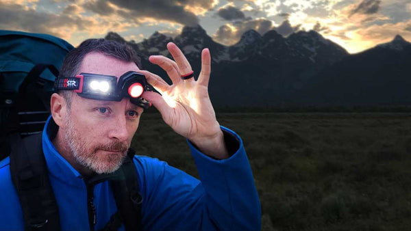 James modeling a flexit headlamp 2.5 from STKR Concepts with hiking gear in front of mountain scene