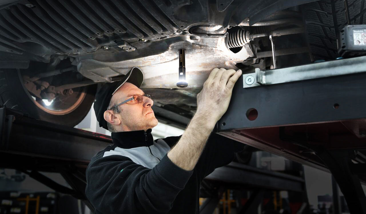 Mécanicien travaillant sous la voiture à l'aide de l'aimant | Fli-Pro télescoping Light par STKR Concepts