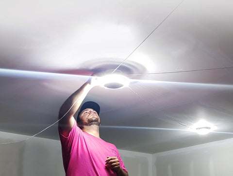 man installing an MPI multi point illumination on his ceiling