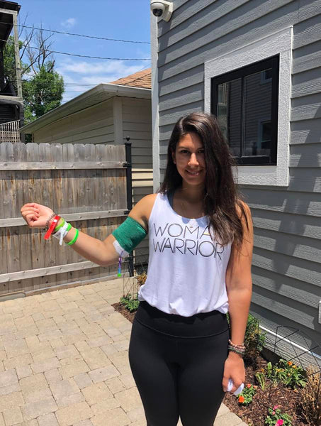 Lyme disease advocate, Ali Moresco, standing on a patio outside with a Lyme Warrior T-shirt on