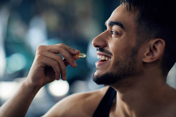 a happy man who’s about to take in a capsule he is holding