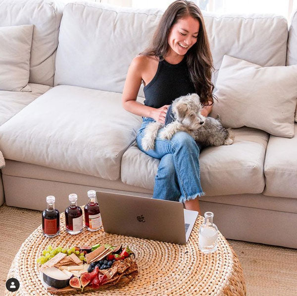 Virtual Wine Tasting Charcuterie Board Woman and Puppy on Couch