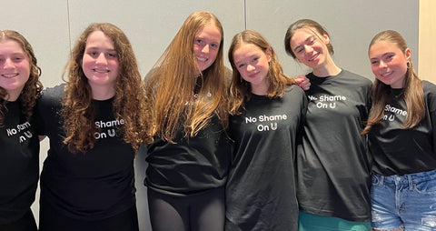 Six girls wearing No Shame On U black t-shirts