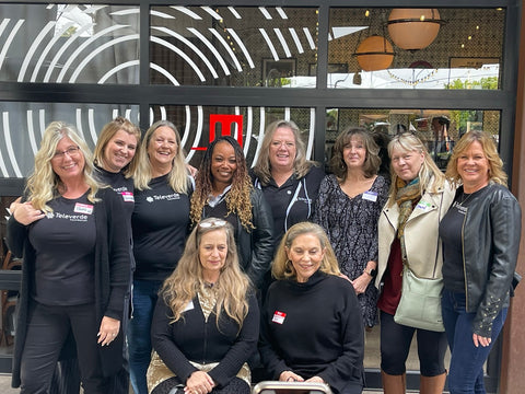 Ten women from Televerde Foundation standing together and smiling at camera