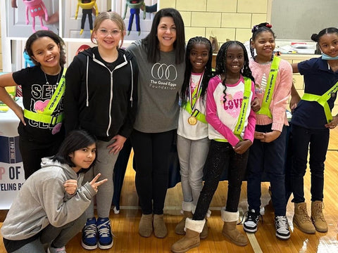 Woman and kids standing and smiling together in a gymnasium