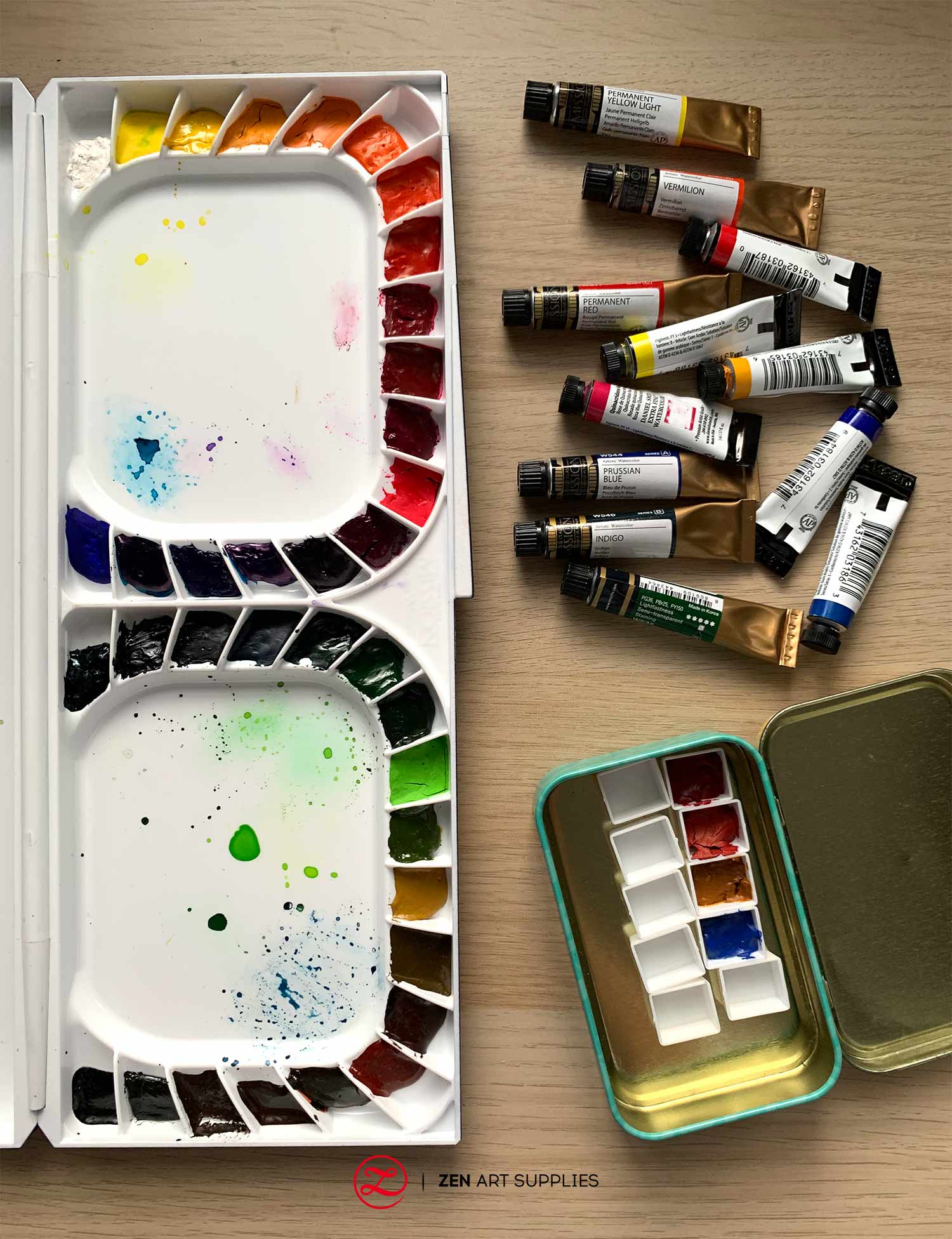 watercolor palette with squeezed out watercolor from tubes and pans filled with watercolor paint.