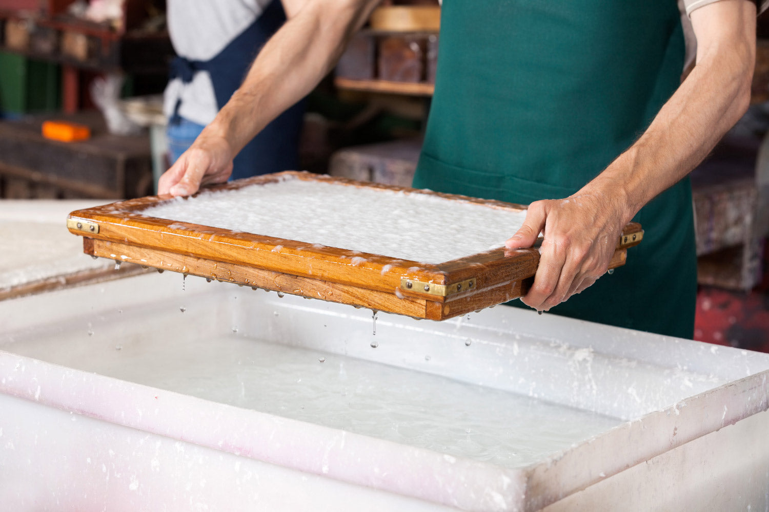 Handmade paper process using mold and deckle.