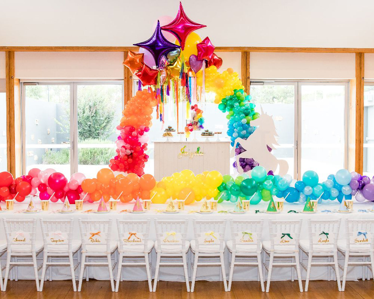 Unicorn Party setup with Kids Table and Rainbow balloon party decorations